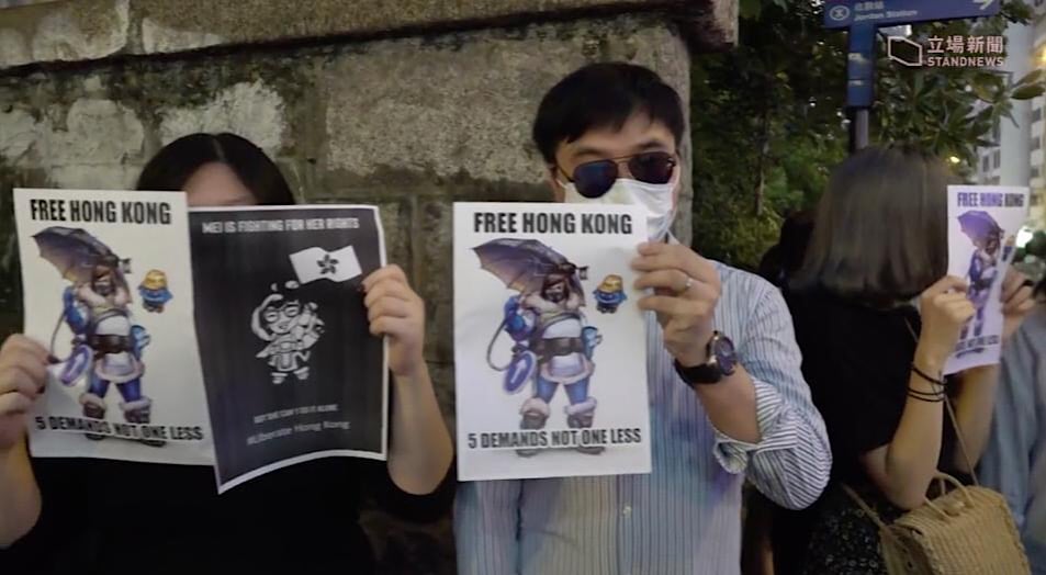 Various pro-democracy Mei signs being held by Hong Kong protestors during a Stand News broadcast.