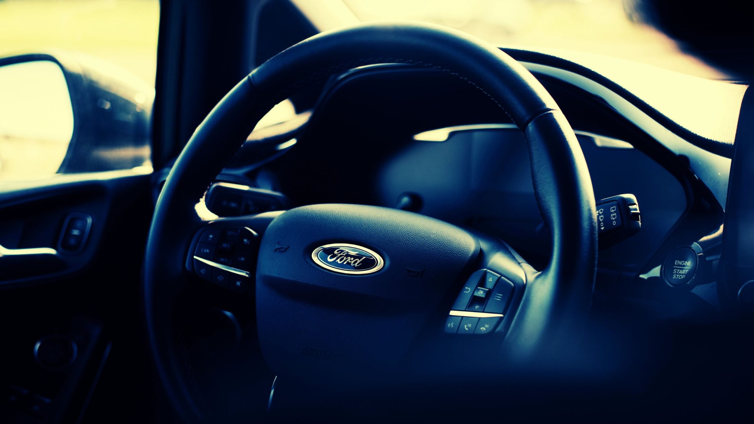 Close-up of a Ford vehicle's steering wheel with the logo prominently displayed.