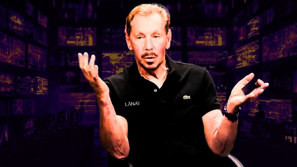 Larry Ellison gesturing with both hands, in front of a dark background featuring various digital screens with glowing graphics.