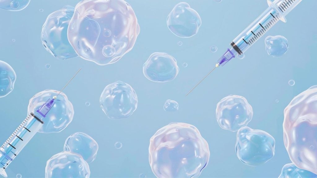 Syringes surrounded by translucent blue bubbles on a light blue background.