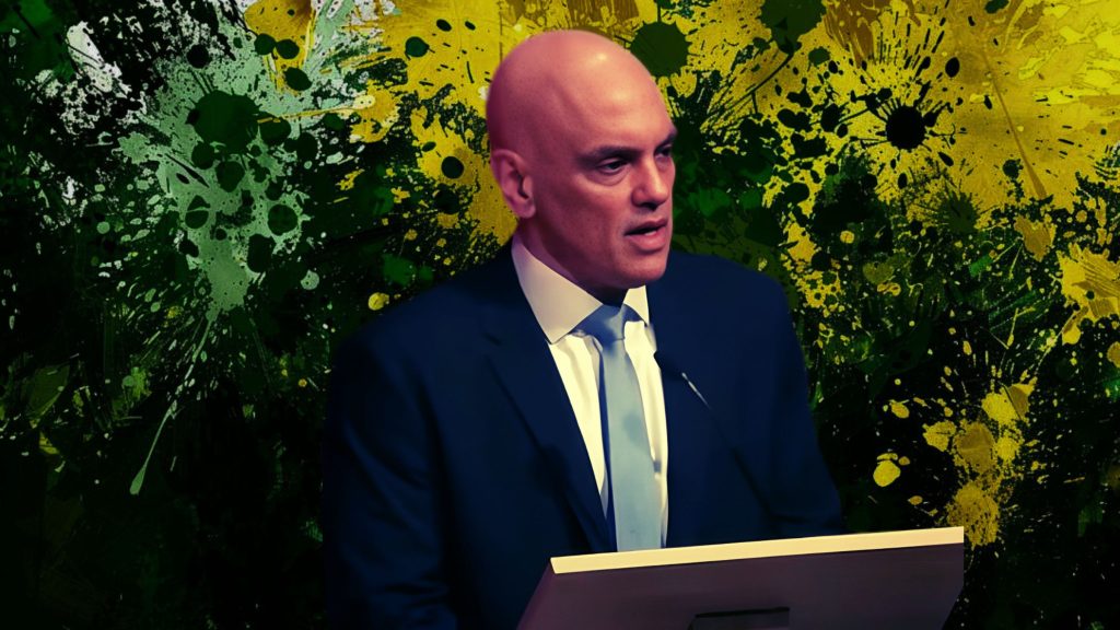 Moraes speaks at a podium against a colorful, abstract background with splashes of green, yellow, and black.