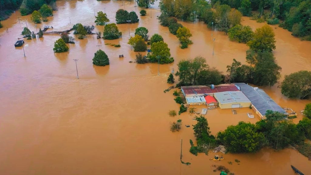 Aerial view of a flooded landscape with submerged buildings and trees.