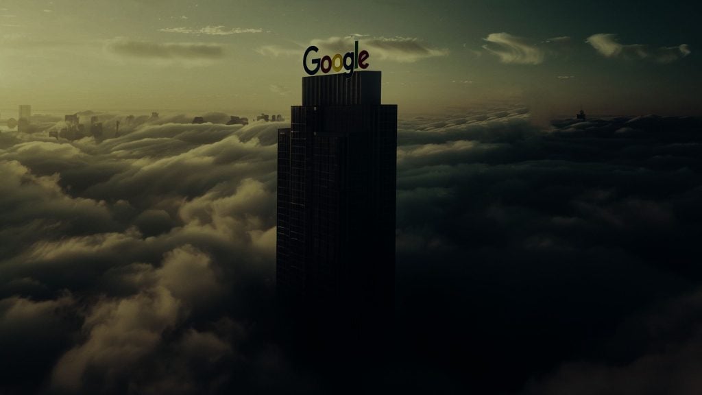 A skyscraper with the Google logo on top, emerging from a sea of clouds at sunset.