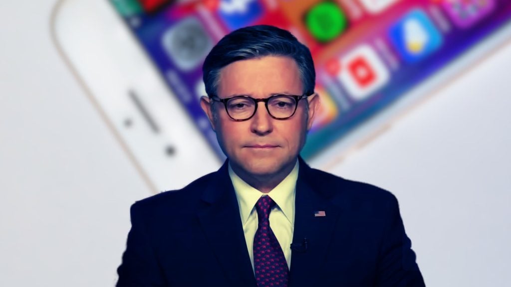 Mike Johnson in a suit and tie with glasses stands in front of a blurred background displaying smartphone apps.