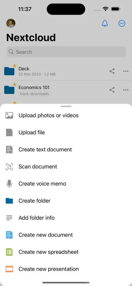 Screenshot of the Nextcloud app on a mobile device showing options such as "Upload photos or videos," "Upload file," "Create text document," and more.