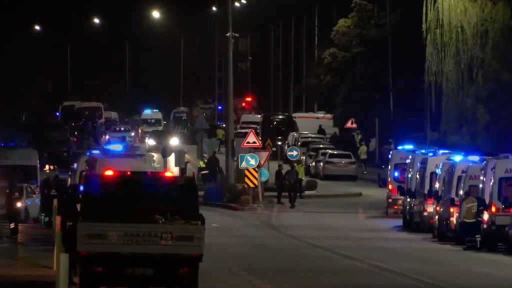 Emergency vehicles with flashing lights on a night street.