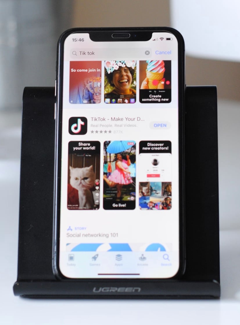 Smartphone displaying TikTok app page on a stand.