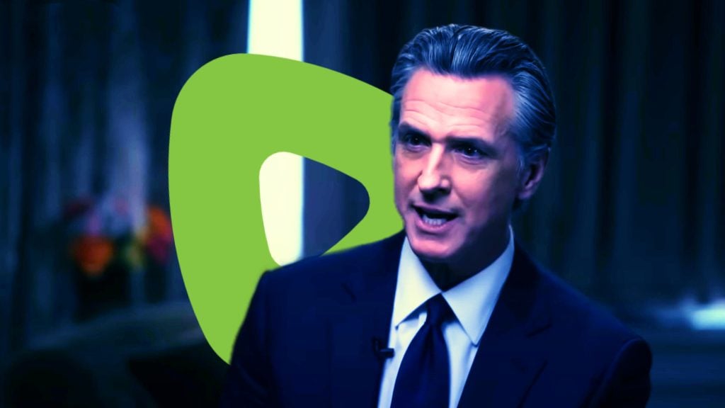 Newsom in a suit speaking with a green abstract shape in the background.