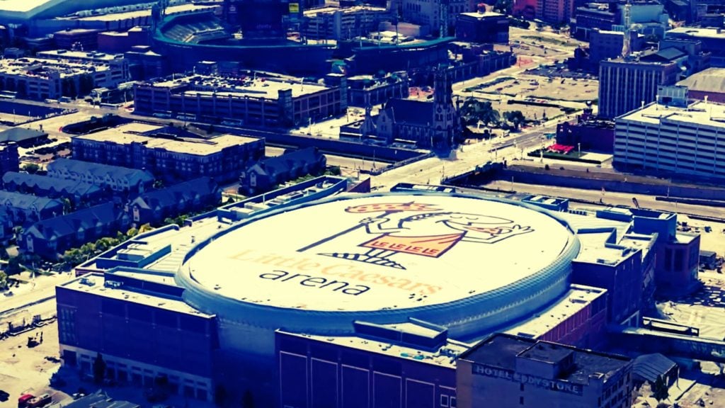 Aerial view of Little Caesars Arena in an urban area.