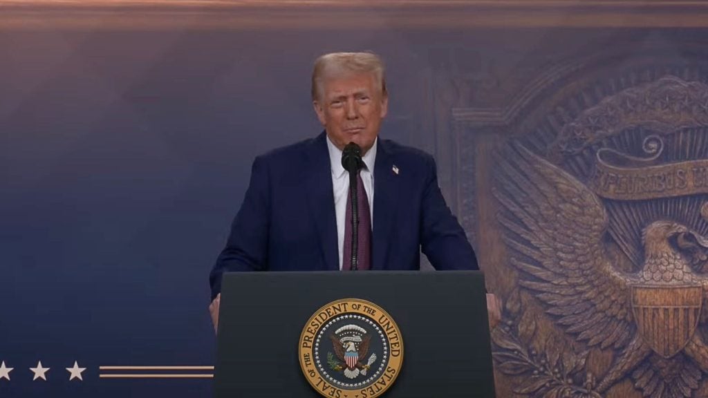 Trump standing at a podium with the seal of the President of the United States, speaking into a microphone.