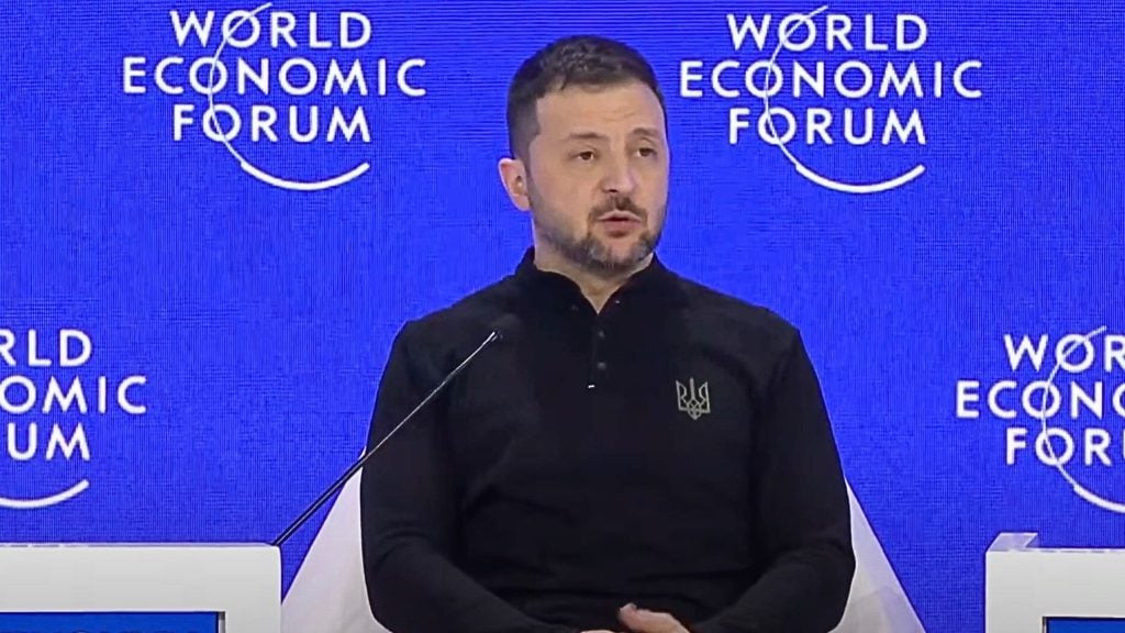 Zelensky at the World Economic Forum event, with the forum's logo in the background.