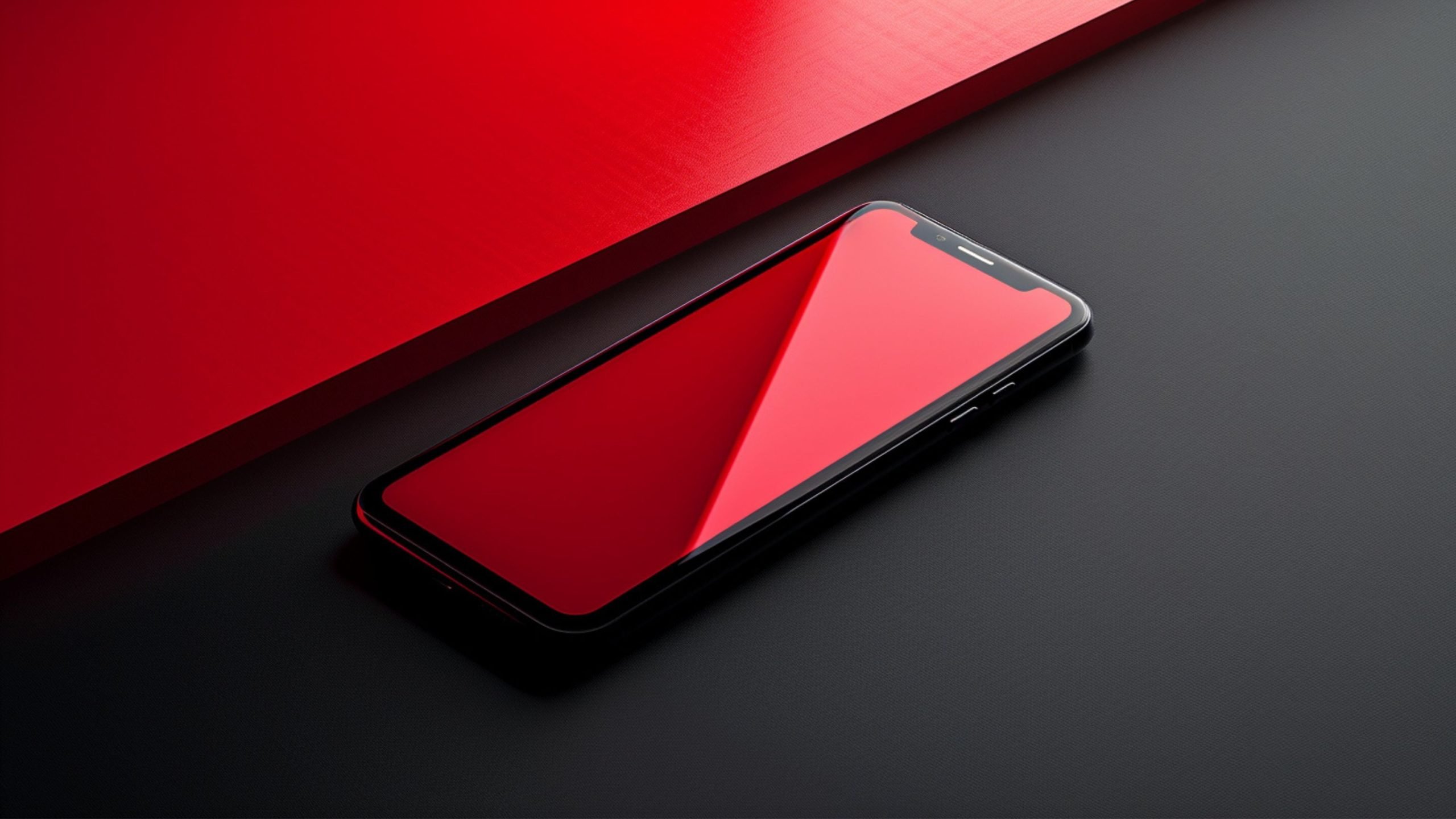 A smartphone with a red screen lying on a black surface next to a red panel.