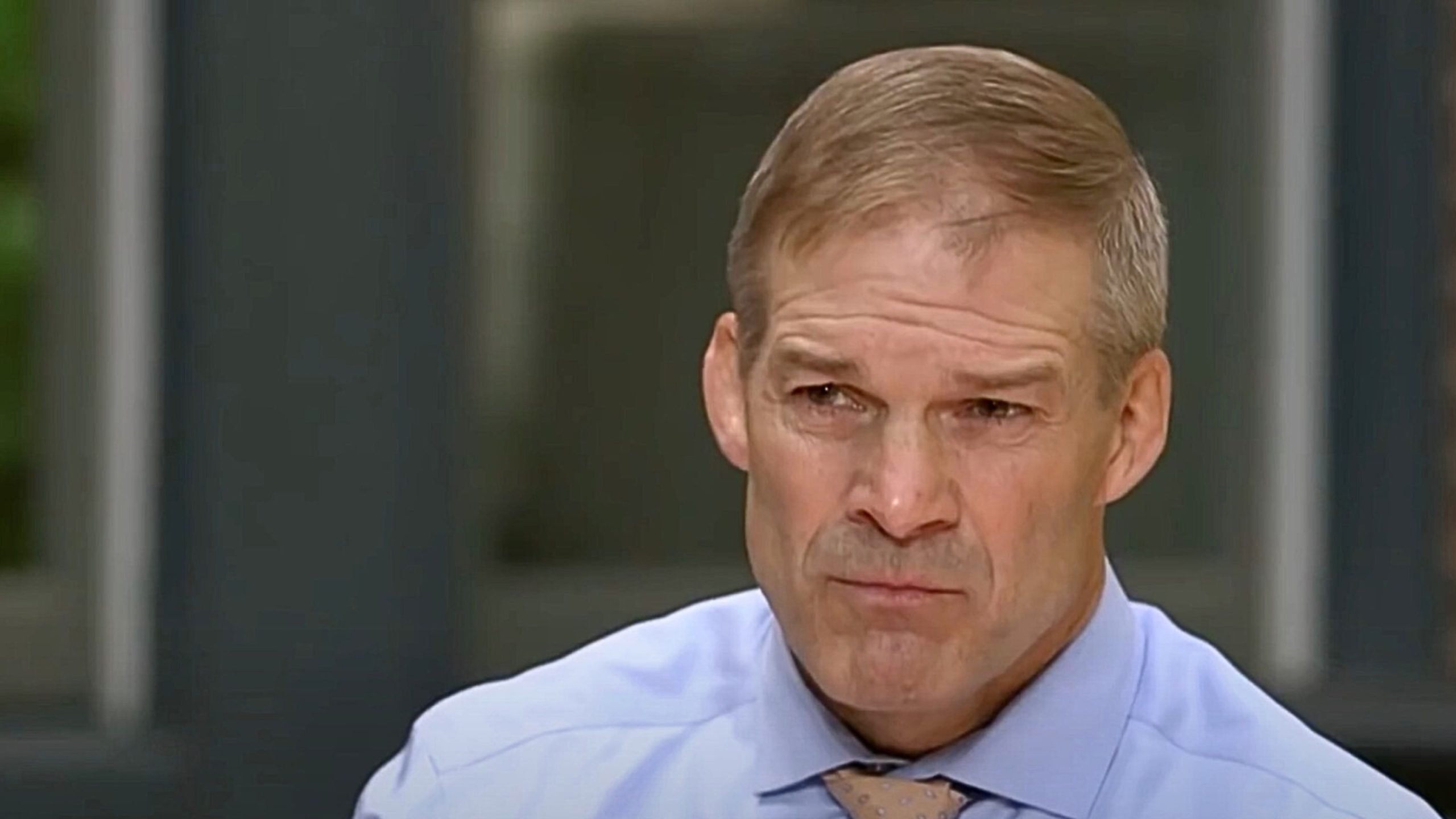 Jim Jordan in a collared shirt and tie, looking seriously into the distance.