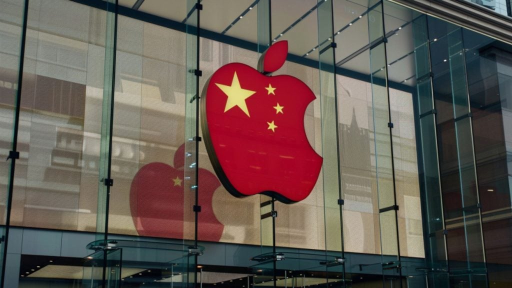 Red Apple logo with the yellow stars of the Chinese flag displayed on a glass storefront building.