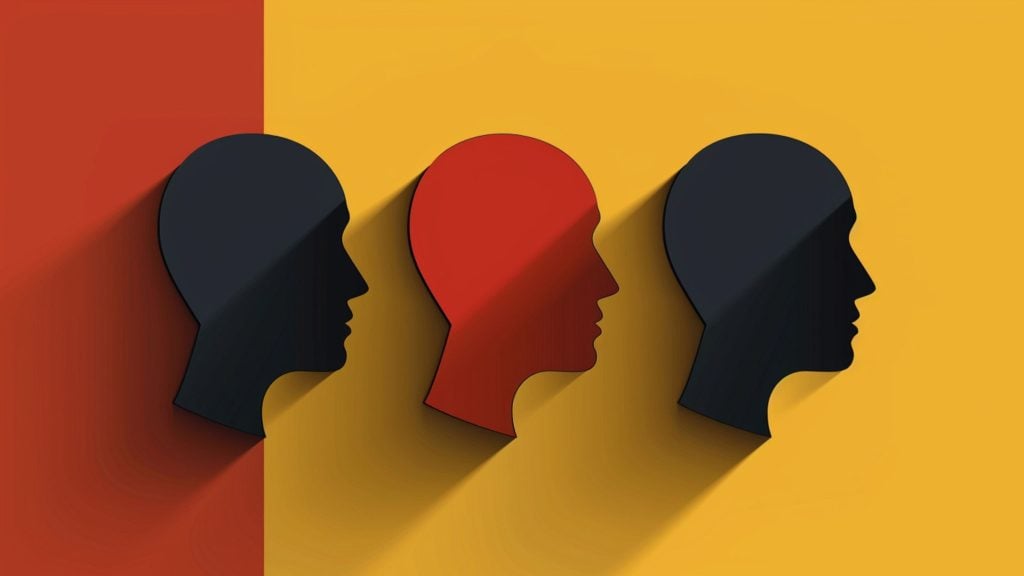 Graphic of three human head silhouettes in profile, with the middle head colored red and the outer two black, set against a background split between red and yellow sections.