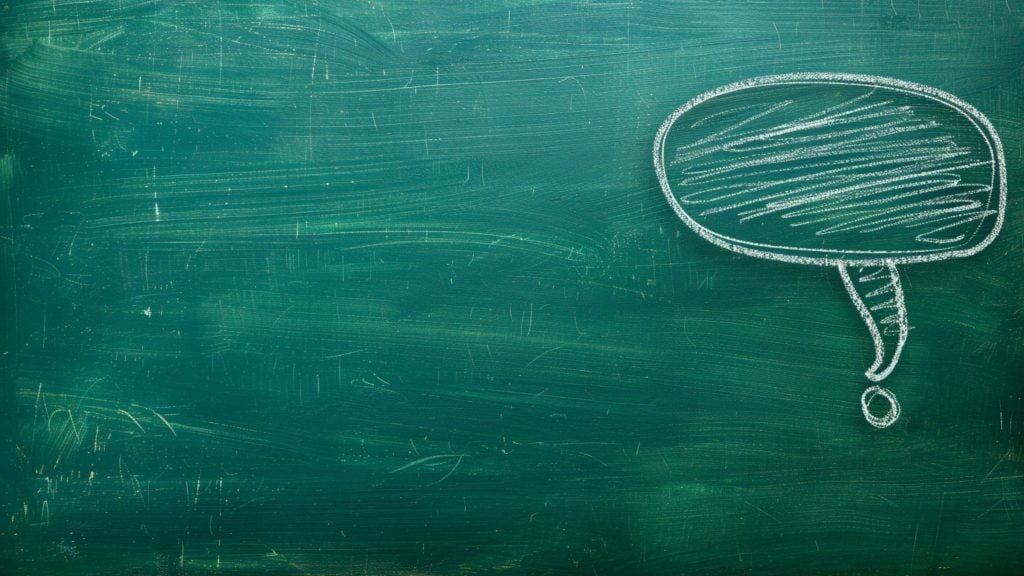 Green chalkboard with a white chalk-drawn speech bubble in the upper right corner, filled with scribbles.