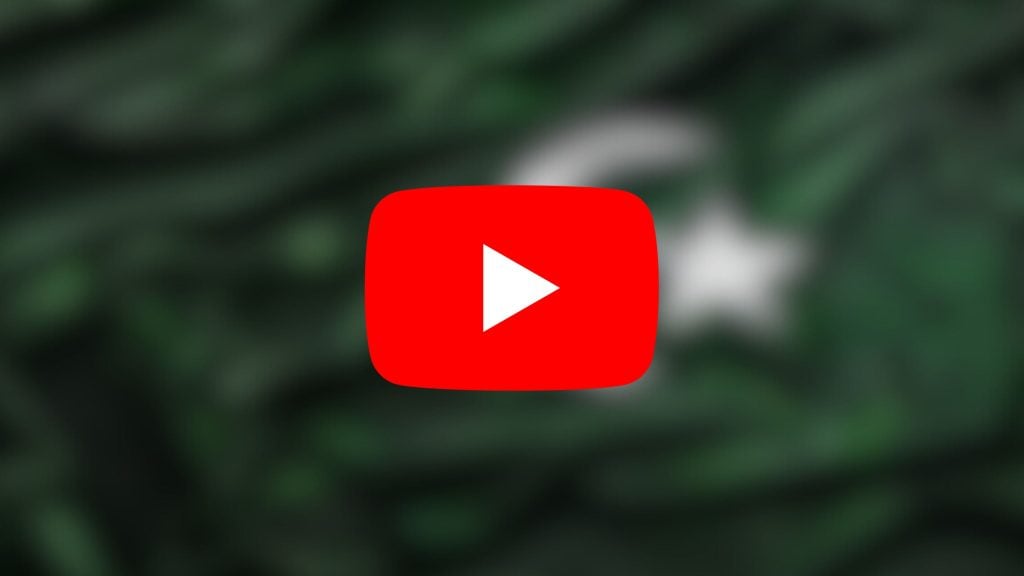 Red YouTube play button icon with a triangular white play symbol in the center on a blurred green and white background