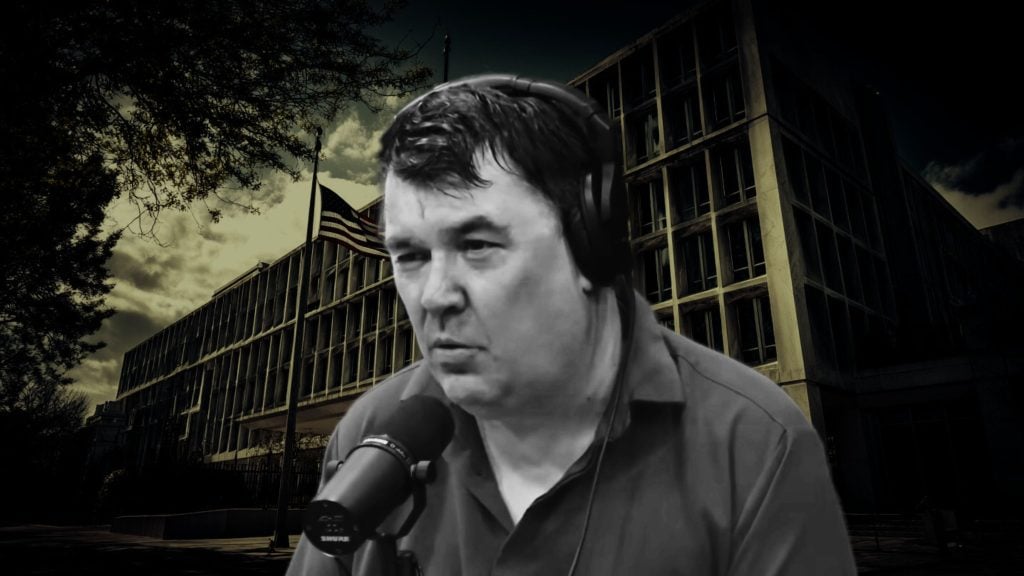 Linehan wearing over-ear headphones and speaking into a studio microphone, composited in grayscale over a dark, ominous government building with an American flag and cloudy sky in the background.