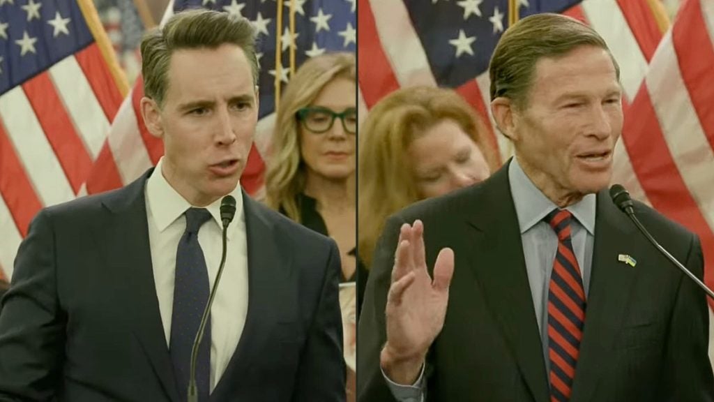Split-frame image showing Hawley and Blumenthal in suits speaking at microphones in front of rows of American flags; the left man looks serious while the right man talks and raises one hand, with several people standing behind them.