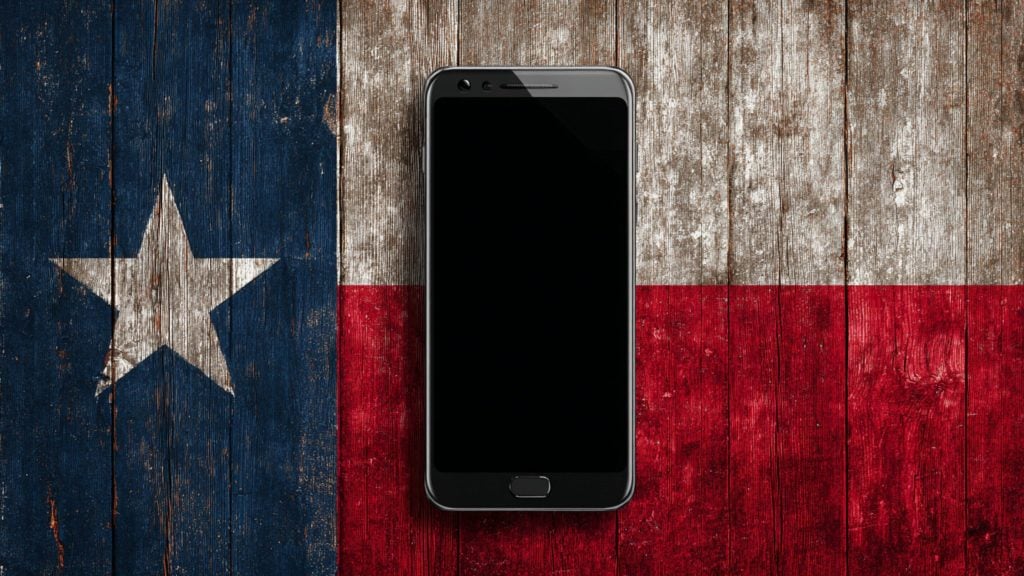 Black smartphone with a blank screen centered on a weathered wooden Texas flag background, showing a white lone star on blue at left and white and red horizontal stripes to the right.
