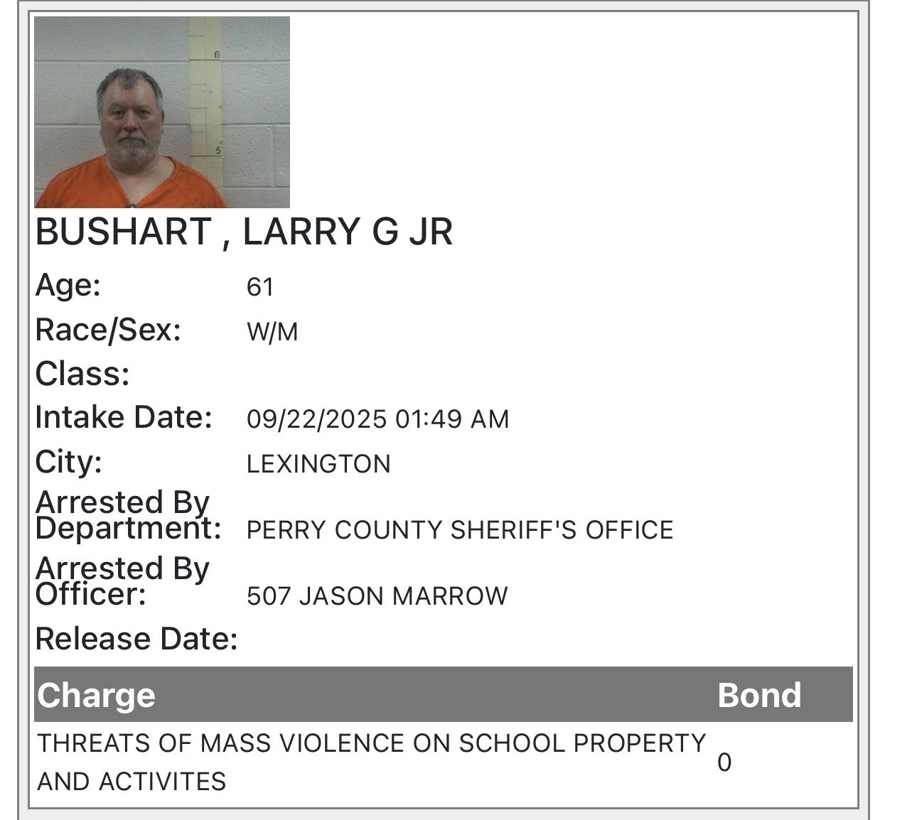 Mugshot-style photo of a bearded man in an orange jail uniform standing before a cinderblock wall and height chart, alongside a booking sheet showing intake details and a charge for threats of mass violence on school property.