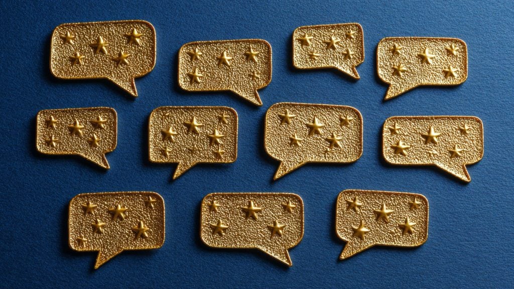 Eleven gold textured speech-bubble pins, each embossed with several raised stars, arranged in rows on a deep blue background.