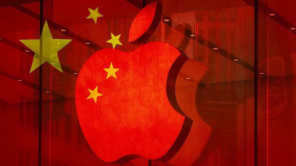 Large red Apple logo overlaid with five yellow stars from the Chinese flag, shown against a red glass storefront backdrop.