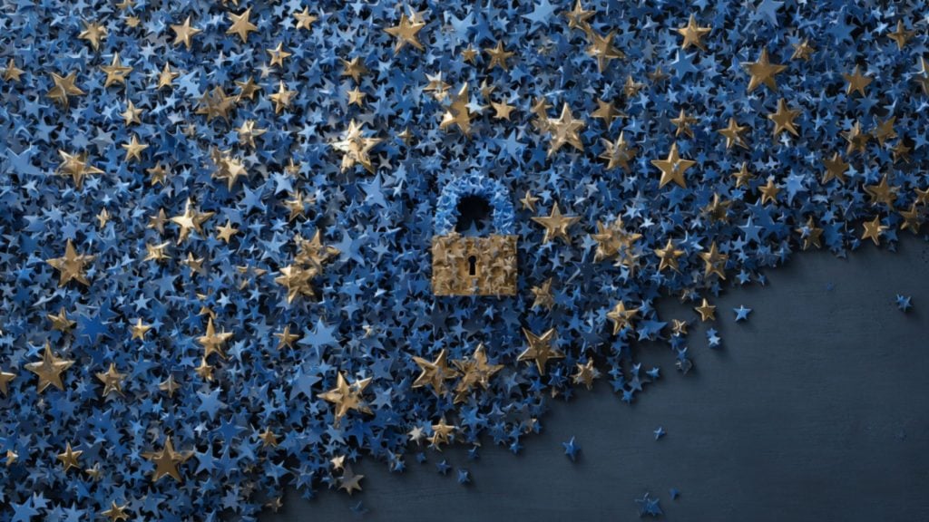 Mass of tiny blue stars with scattered gold stars on a dark blue background, arranged to form a central padlock silhouette with a gold lock body, a blue shackle, and a visible keyhole.