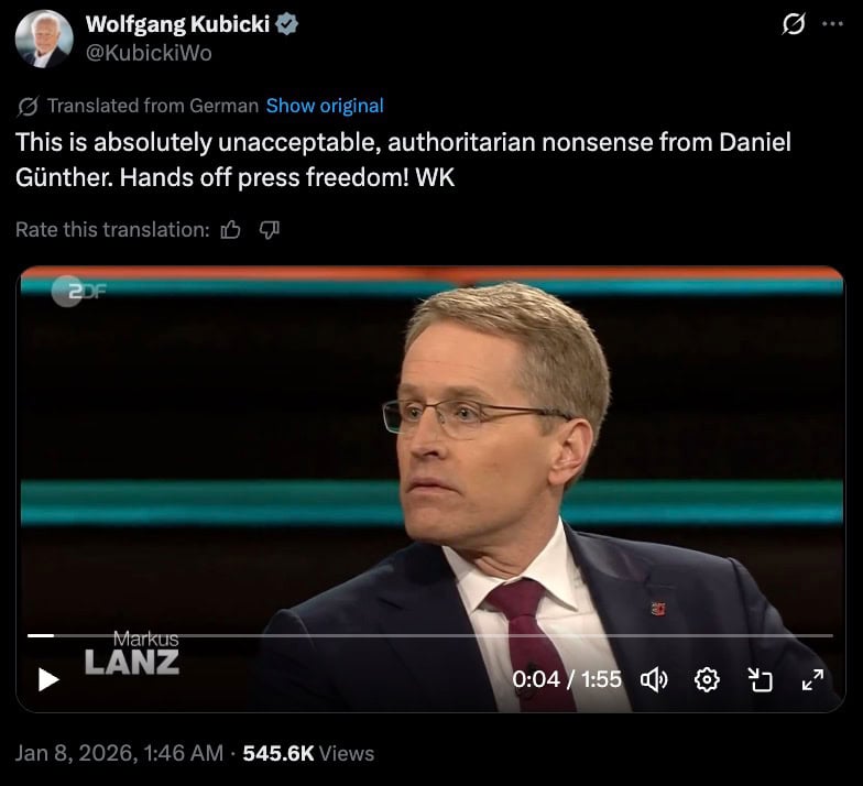 Tweet calling out an authoritarian move with hands off press freedom over a TV shot of a suited man in glasses.