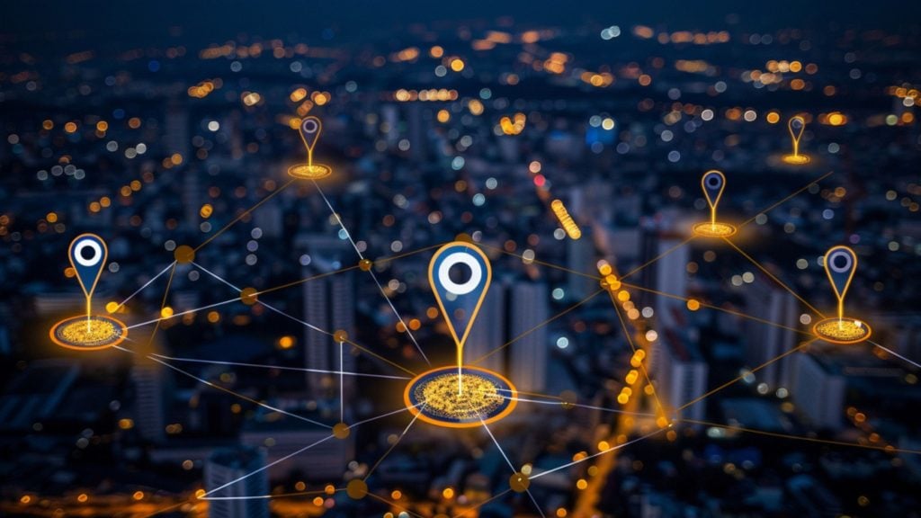 Glowing digital location pins connected by network lines hovering over a blurred nighttime city skyline with bokeh lights.