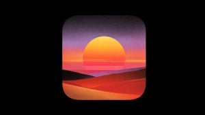 Rounded-square icon showing a large yellow sun setting over layered red-orange dunes beneath a purple-to-orange gradient sky
