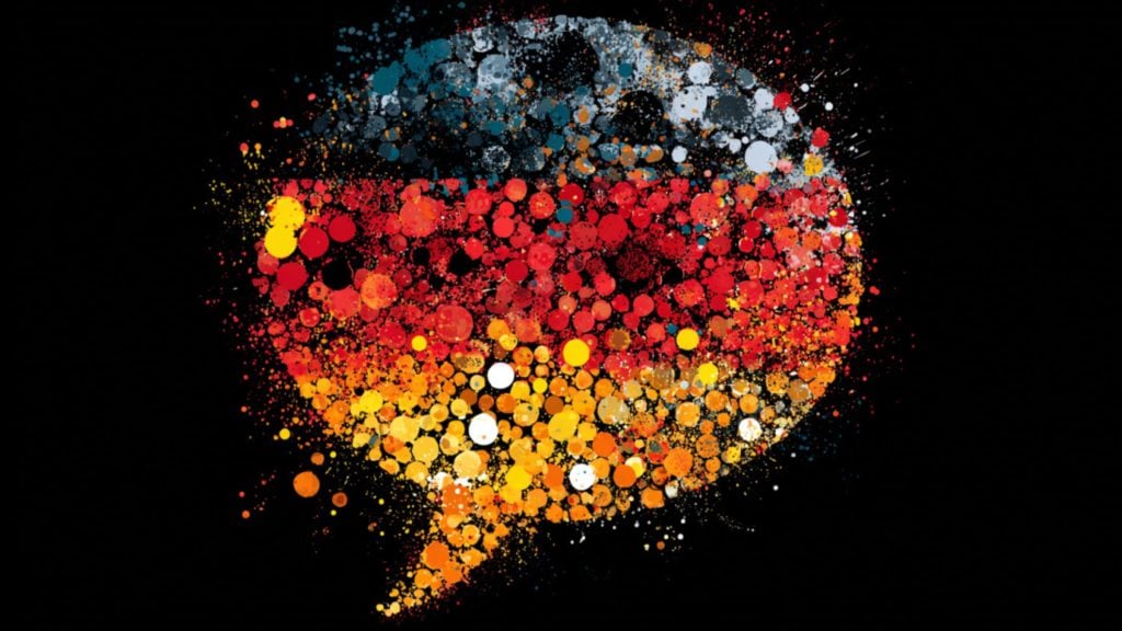 Colorful speech-bubble made of layered paint-splatter dots in blue, red, orange and yellow on a black background.