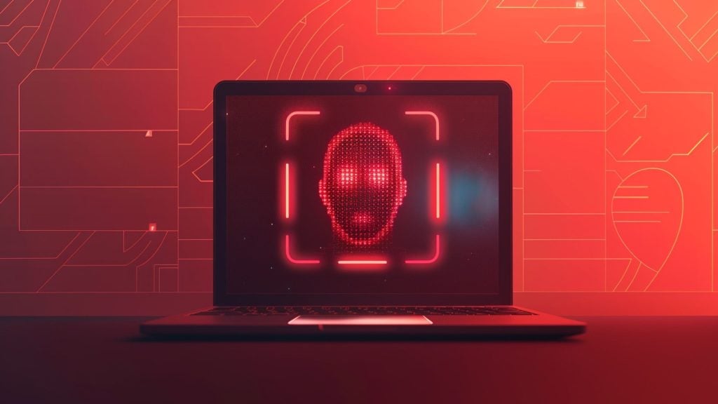 Laptop displaying a red digital face within a scanning frame, set against a red, circuit-patterned background.